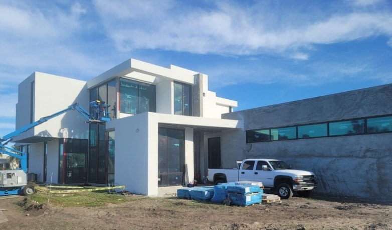 Modern commercial building under construction with large impact glass windows